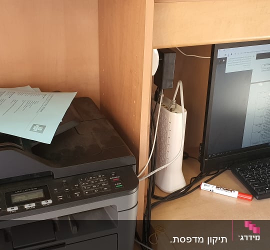 מדפסת ומחשב עם מסך פתוח על מסמך